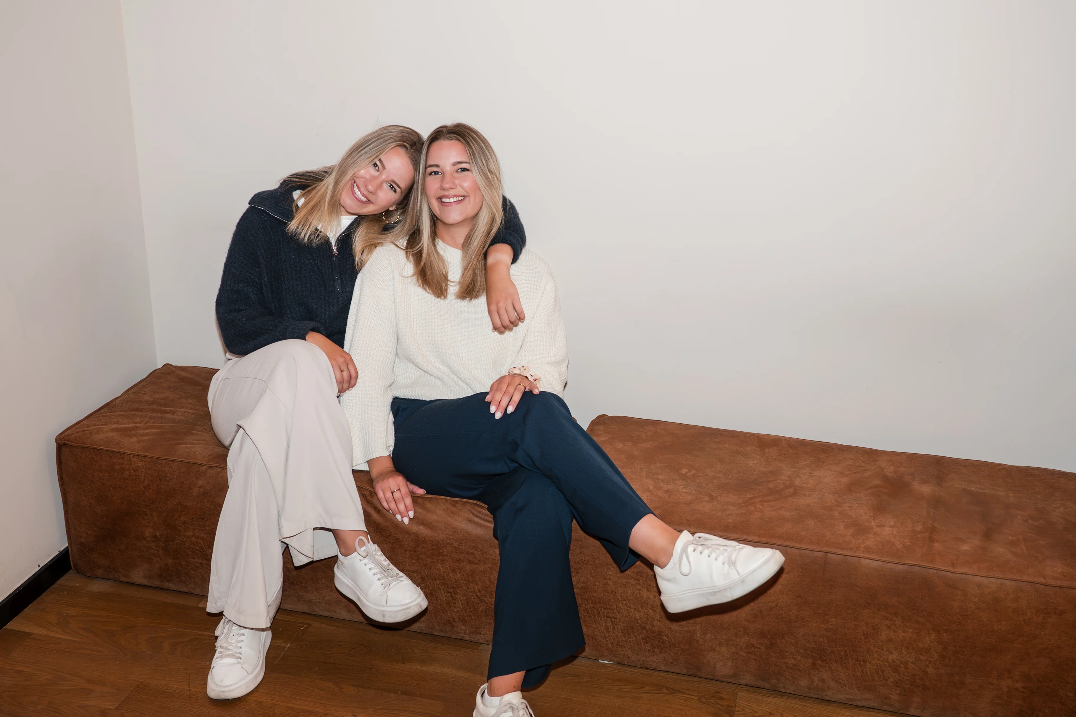 Nathi and Juli Daum, sitting together on a leather bench