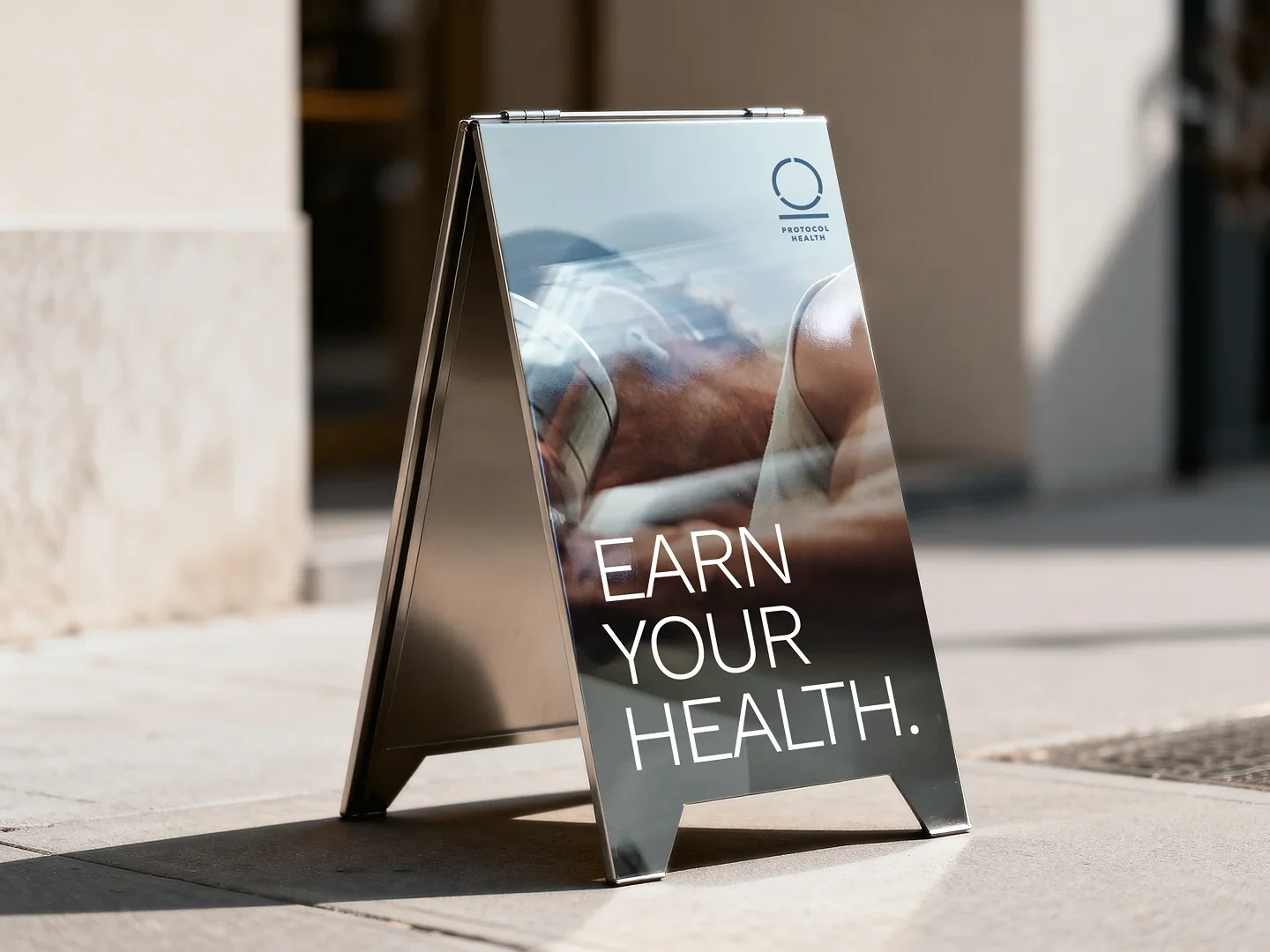 A pavement sign outside the studio: Earn your health